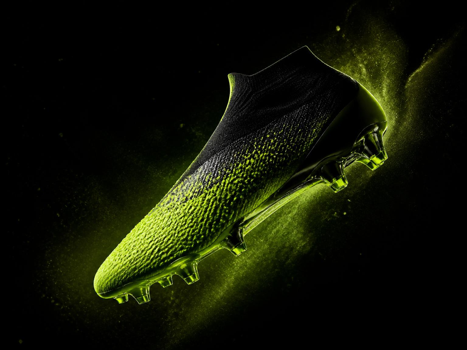 Volt green football boot on a black studio background